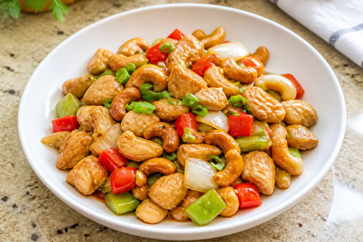 Cashew chicken stir-fry with chicken pieces, roasted cashews, bell pepper, onion, and green onion